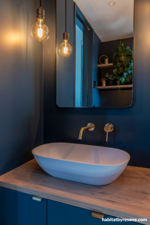 Master en-suite painted in deep navy blue combines luxury and moody atmospheres