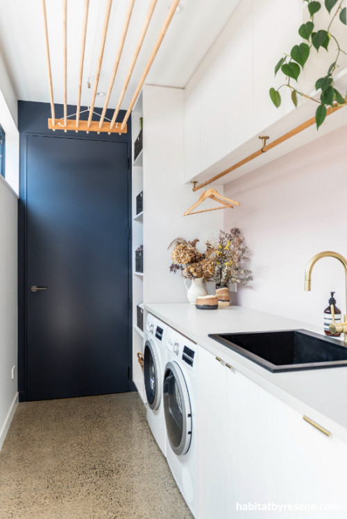 White on the walls & ceiling and navy blue for the door in this stylish laundry 