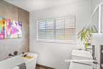 “In the bathroom, Resene Sea Fog was chosen to offset darker grey and black tones while enhancing the effect of white feature tiles,” Charlotte says. The ceiling and trims are painted in Resene Black White. 