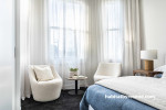 Inviting and comfortable furniture adorns this bedroom, and subtle floating sheer window dressings allow for diffused light, creating a serene atmosphere. Walls painted in Resene Wan White and trims in Resene Eighth Black White. 