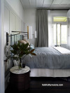 The delightful master bedroom features a panelled headboard painted in Resene Half Ash, with Resene Quarter Ecru White on walls and Resene Half Black White on trims and detailing. 