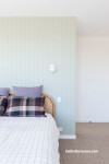 Bedroom with panelled wall painted in soft light green tone