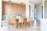 Dining space brightened with white tones and natural wood panelling