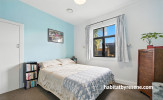 Bedroom featuring white walls and ceiling and a soft blue feature wall