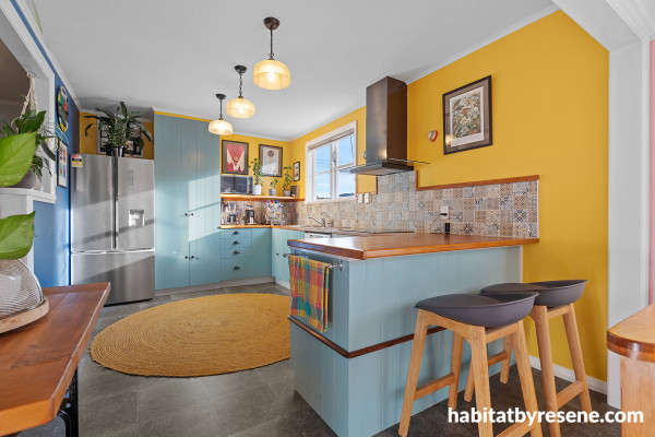 Kitchen with bright yellow walls and soft blue cabinets.