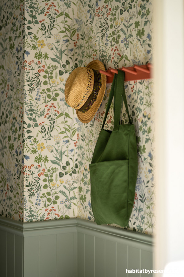 The entryway features a bright pop of Resene Apple Blossom painted on the coat rack, with Resene Robin Egg Blue on panelling complementing the existing wallpaper. For a similar design, try Resene Wallpaper Collection 465310. 