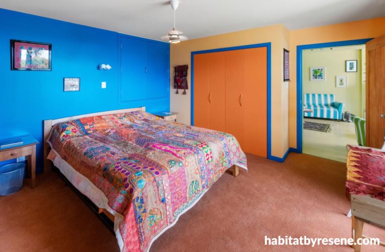 Bedroom featuring bold blue and pale orange walls