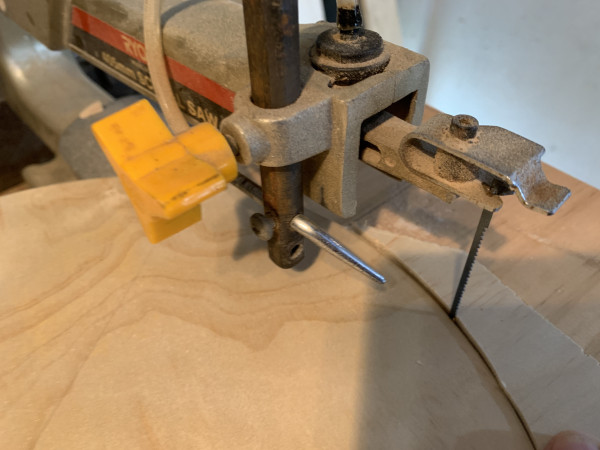 A saw cutting a curve into a piece of wood