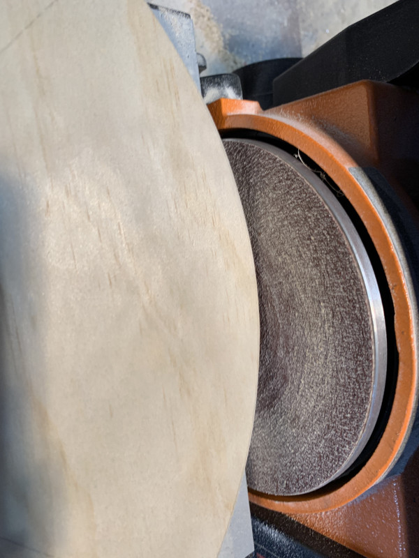 A sander sanding the edge of a piece of wood