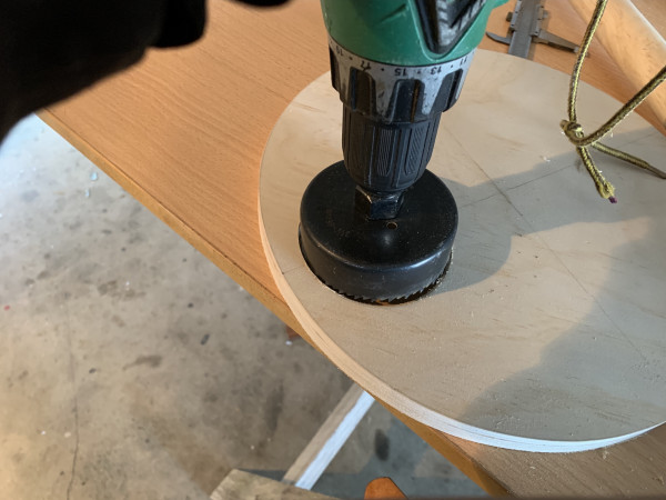 A drill cutting a circle into a piece of wood