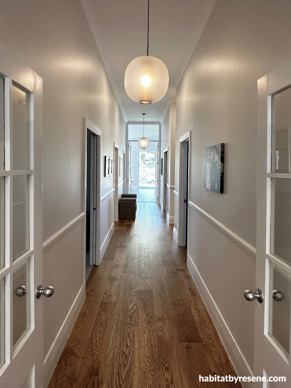 In the hallway, a dado rail was added, with the lower part painted in Resene Alabaster and the upper part in Resene Sea Fog, enhancing the traditional feel. 