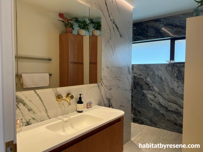 Bathroom with marble-look panels and painted in Resene Wheatfield