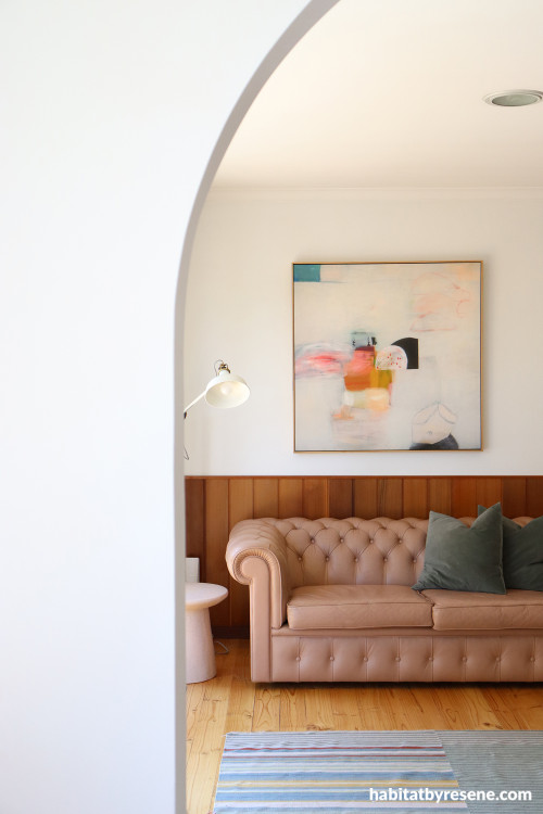 Living area featuring an archway and wood panelling