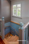 Natual wood staircase with walls painted half in grey and half in blue