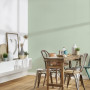 Dining space with gentle green wallpaper 