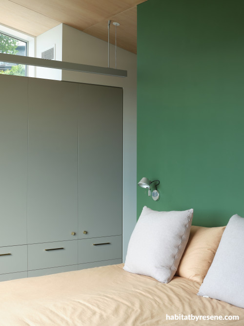 A bedroom with a green wall in Resene Ranger