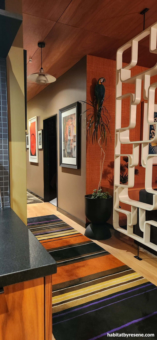 A mix of vibrant mid-century shades adorns the hallways. The room divider is painted in Resene Ecru White, with two custom Resene colours, ‘Cohen Green’ – try Resene Highball as an alternative on the left and ‘Callahan Brown’ on the right – try Resene Dragon as an alternative. The ceiling is finished in Resene Aquaclear satin and trims in Resene Nero.  