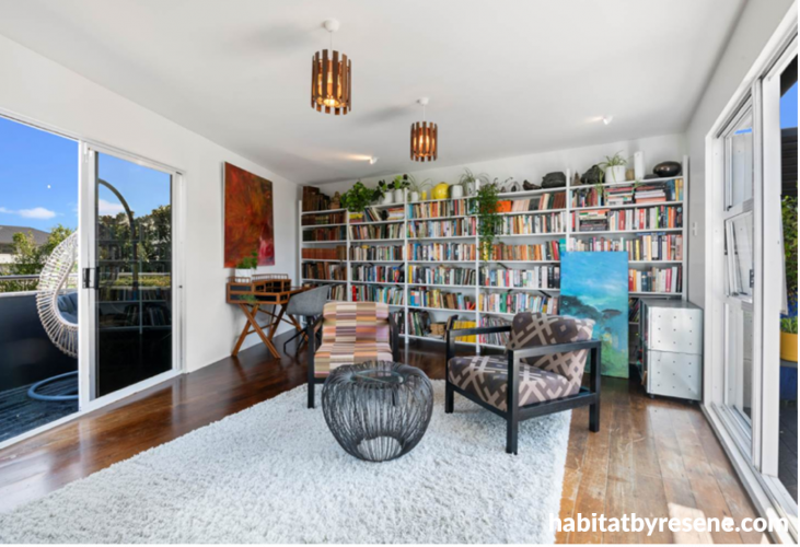 A white sitting room and library painted in Resene Alabaster