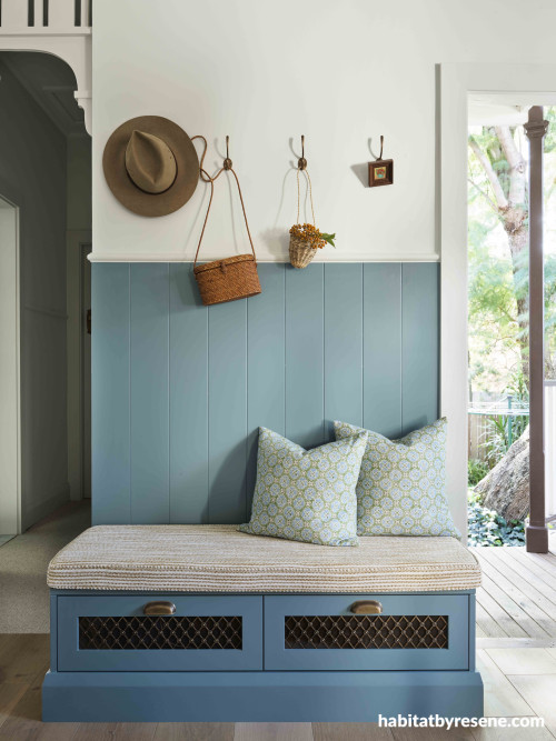 A blue entrance with a bench seat and cushions