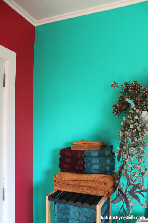 Bedroom featuring bright peacock green and deep red tones