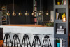 apartment, kitchen, benchtop, hanging lights, gold lighting, dark grey paint, barstools 