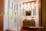 white bathroom, striped bathroom, oak vanity, blue and white paint, vintage bathroom