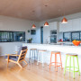 kitchen, white kitchen, wood ceiling, coloured bar stools, timber floors, white living room 