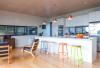 kitchen, white kitchen, wood ceiling, coloured bar stools, timber floors, white living room 