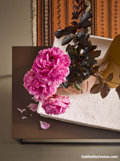 rattan accessories, rattan basket, orange rug, pink flowers, painted cases, pink vase