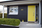 house exterior, black house, yellow front door, bright yellow door, painted black bricks 