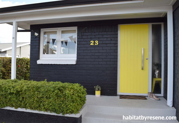 house exterior, black house, yellow front door, bright yellow door, painted black bricks 