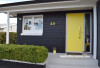 house exterior, black house, yellow front door, bright yellow door, painted black bricks 