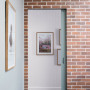 hallway, entranceway, white hallway, grey door, brick interior wall, brick feature wall 