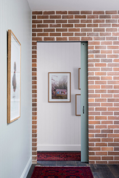 hallway, entranceway, white hallway, grey door, brick interior wall, brick feature wall