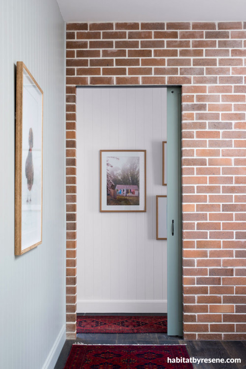 hallway, entranceway, white hallway, grey door, brick interior wall, brick feature wall