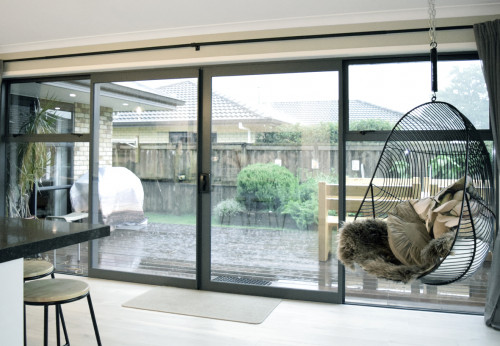 indoor outdoor flow, kitchen, living area, neutral dining room, deck, indoor hanging chair