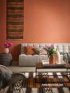 orange lounge, orange living room, hanging rug, brown and orange, resene sunbaked 