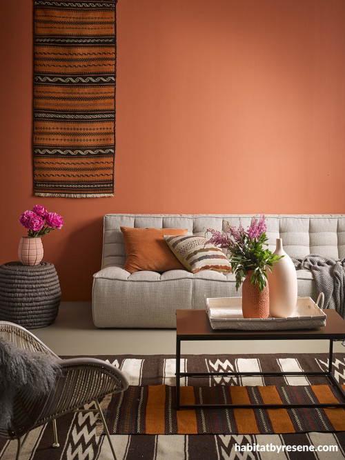 orange lounge, orange living room, hanging rug, brown and orange, resene sunbaked 