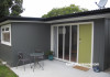 1970s home, house exterior, sleepout, grey exterior, green door, grey sleepout